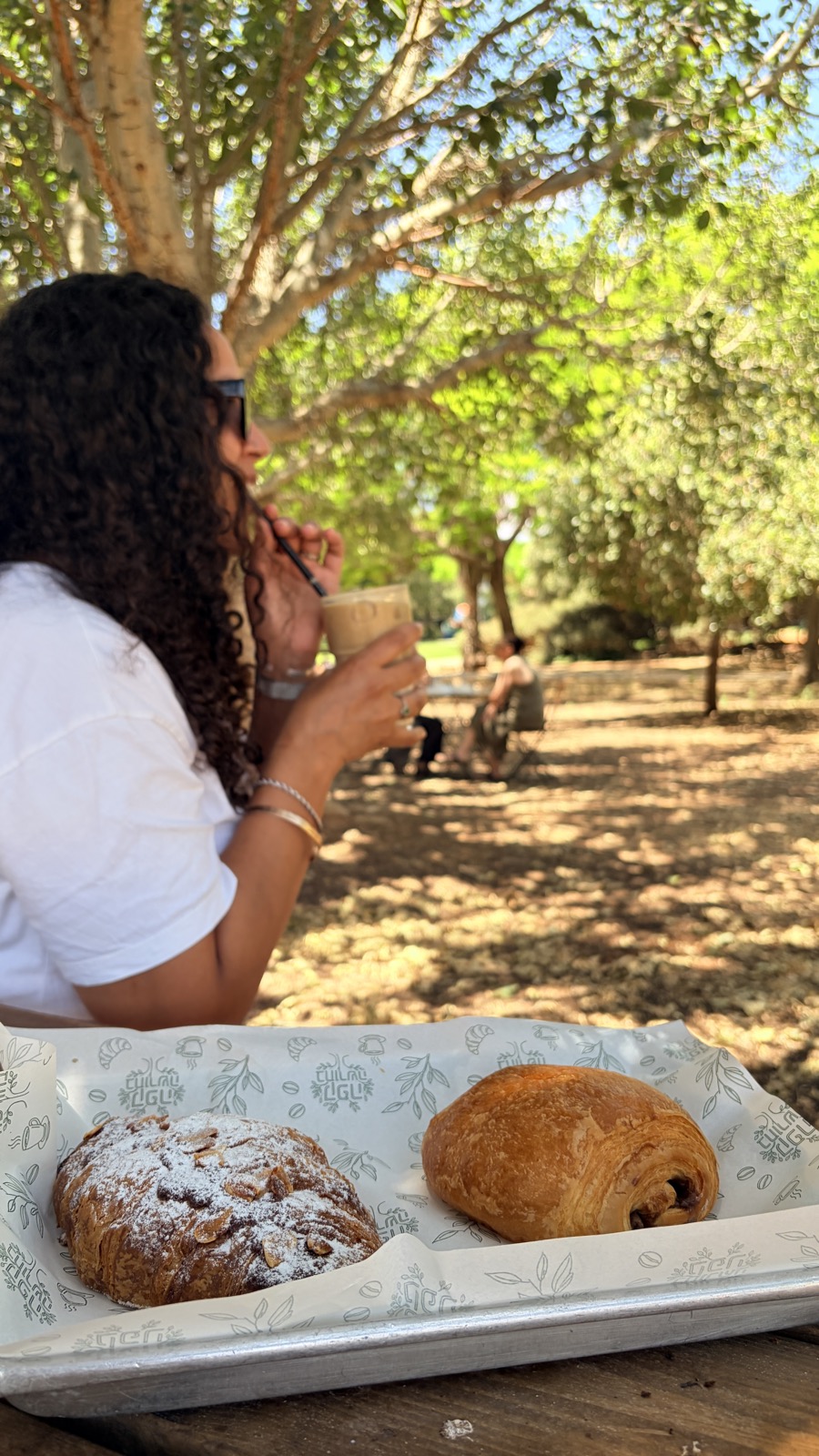 ישיבה בצל העצים בקפה בחורשה עם קפה ומאפים